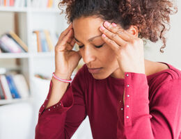  A woman massages her temples.